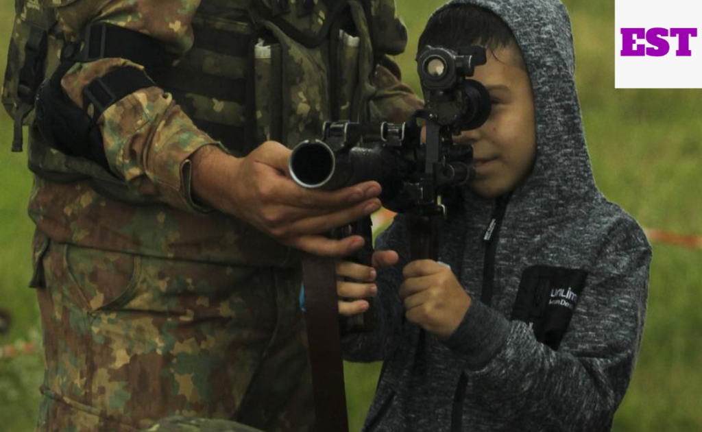 Teenager being trained how to operate weapon